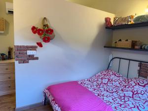 a bedroom with a bed with a pink blanket at Location Vacances à Laudun in Laudun