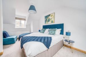 a bedroom with a bed and a blue headboard at Luxury Cottage in the New Forest with Log Burner in Redlynch
