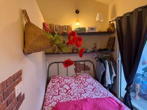 a small bedroom with a pink bed and a closet at Location Vacances à Laudun in Laudun