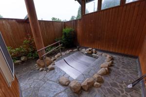 an outdoor patio with a wooden fence and a bench at 灯ノ環tomonowa in Mitsuwa