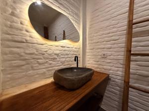 a bathroom with a stone sink and a mirror at Mu Homestay Tetebatu in Tetebatu