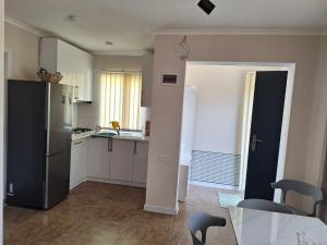 a kitchen with a refrigerator and a table with chairs at Paradise Mtskheta in Tbilisi City