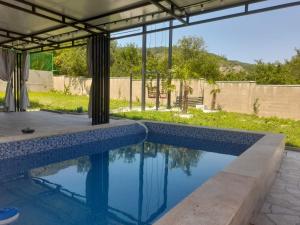 a swimming pool in a backyard with a house at Paradise Mtskheta in Tbilisi City