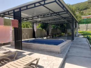 a swimming pool under a metal pavilion with a hot tub at Paradise Mtskheta in Tbilisi City