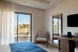 a bedroom with a bed and a desk and a television at Atlantica Callisto in Ayia Napa