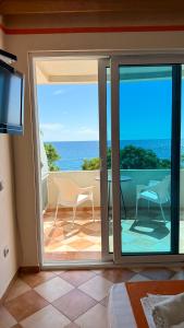 a room with a sliding glass door with a view of the ocean at Apartments Deus in Dobra Voda