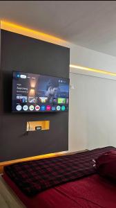 a bedroom with a flat screen tv on the wall at Deed Apartemen in Gresik