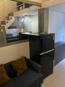 a living room with a couch and a kitchen at Deed Apartemen in Gresik