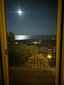 a view of the ocean at night from a balcony at Villa Thea Ferienhaus mit Meerblick auf Kefalonia in Sarláta