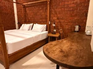 a bedroom with a bed and a wooden table at Mu Homestay Tetebatu in Tetebatu