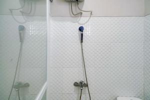 a bathroom with a toilet and a shower at Urbanview Hotel Bari Syariah Palembang By RedDoorz in Sukarami +19 photos