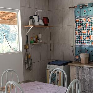 a kitchen with a table and chairs and a stove at Casa amarela in Gonçalves +22 photos