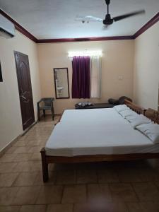 a bedroom with a large bed and a mirror at krishnageeth 4bedroom villa in Guruvāyūr