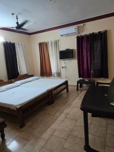 a bedroom with a bed and a flat screen tv at krishnageeth 4bedroom villa in Guruvāyūr