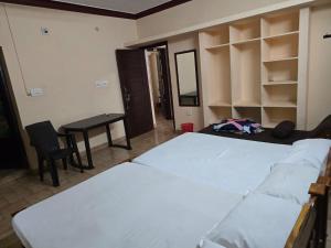 a bedroom with a bed and a desk and a table at krishnageeth 4bedroom villa in Guruvāyūr