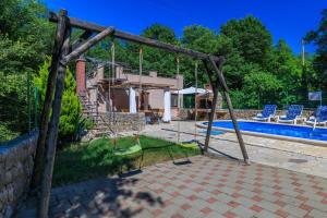 a swing set in front of a swimming pool at Villa Adry 2 in Bribir