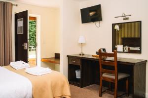 a hotel room with a desk and a chair at Red Lion Inn and Motel in York