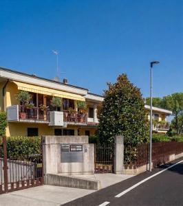 a yellow house with a balcony and a fence at Azzurro Garda in Sirmione