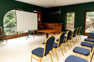 a conference room with chairs and a piano at Hotel Anna Mátrafüred in Mátrafüred