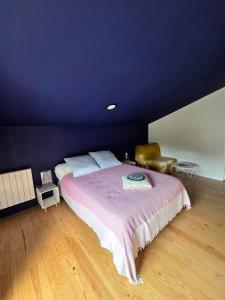 a bedroom with a large bed with a purple wall at Chambre d'hôtes Ahetzina in Ahetze