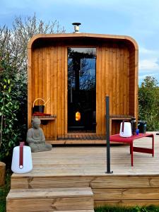 a wooden cabin with a bench and a table at Chambre d'hôtes Ahetzina in Ahetze