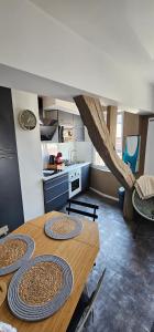 a kitchen with a wooden table in a room at Le petit Rouen in Rouen