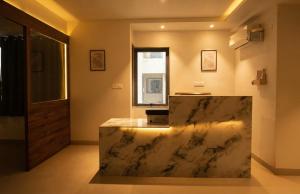 a large marble counter in a bathroom with a window at Hotel Layover Stay-3 Minutes From the Airport in Jaipur