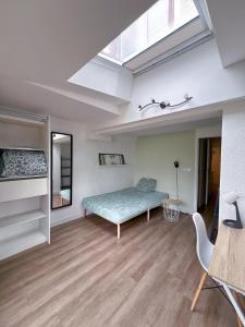 a bedroom with a bed and a skylight at Zen & uS Maison entière in Margny-lès-Compiègne