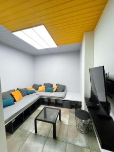 a living room with a couch and a tv at Zen & uS Maison entière in Margny-lès-Compiègne
