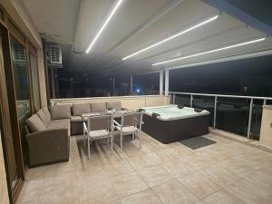 a balcony with a couch and a table and chairs at YS Residence in Sunny Beach