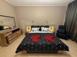 a bedroom with a black bed with red pillows at YS Residence in Sunny Beach +29 photos