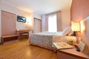 a hotel room with a bed and a desk with a laptop at La Rocca Sport & Benessere in Châtillon