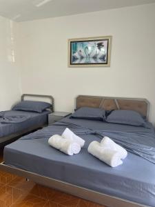 two beds in a room with towels on them at Alira Rooms in Pogradec +2 photos