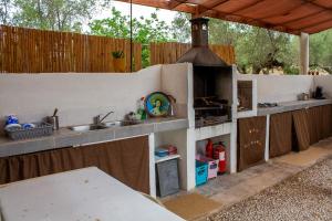 an outdoor kitchen with a sink and a stove at Paraiso Bell Tent - Glamping with Pool in Nature in Tortosa