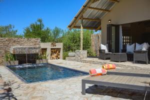 a swimming pool with a fountain in a yard at Glen Harry Game Reserve in Graaff-Reinet