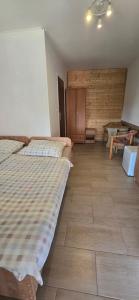 a bedroom with two beds and a wooden wall at Promyk 2 in Rewal