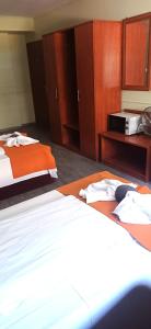 a hotel room with two beds and a microwave at Atlantic Hotel in Budapest