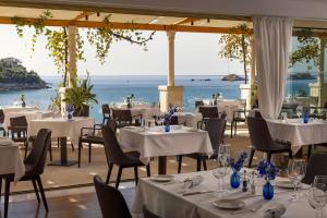a restaurant with tables and chairs with a view of the ocean at Hotel More in Dubrovnik