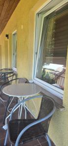 a table and chairs on a balcony with a window at Promyk 2 in Rewal +19 photos