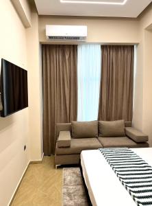 a living room with a bed and a couch at Skampa Apartment in Elbasan