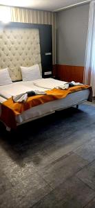 a large bed in a bedroom with a large bedvisor at Atlantic Hotel in Budapest +47 photos