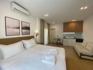 a bedroom with a white bed with towels on it at Ξενώνας Λίθος in Kato Loutraki