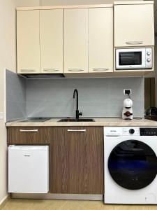 a kitchen with a washing machine and a sink at Skampa Apartment in Elbasan