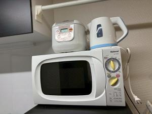 a microwave with a coffee pot on top of it at 板橋 RCアネックス Rc208 in Tokyo