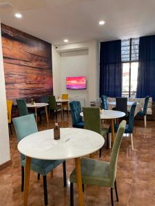 a restaurant with tables and chairs and a tv at New House Kobuleti 2 in Kobuleti