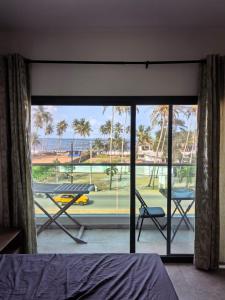 a bedroom with a view of a patio with a table and chairs at Résidence Leyla in Abidjan