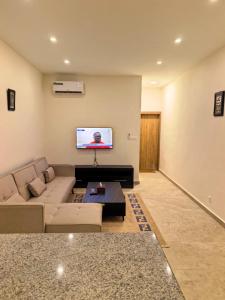 a living room with a couch and a flat screen tv at Résidence Leyla in Abidjan