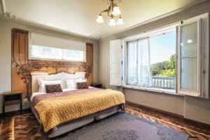 ein Schlafzimmer mit einem Bett und einem großen Fenster in der Unterkunft Chalet Saudade in Sintra + 168 Fotos