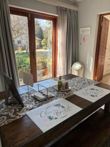 a dining room table with a bottle of wine on it at Olive Branch Cottage off grid in Benoni
