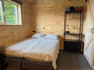 a bedroom with a bed and a cabinet and a window at B&B Tinkunakama in Ouddorp